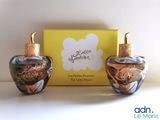 deux flacons de parfum posés l'un à côté de l'autre sur une table