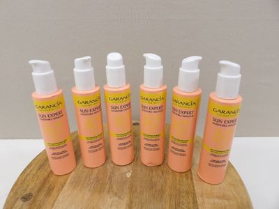 six bottles of sunscreen lotion sitting on top of a wooden board