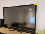 a flat screen tv sitting on top of a wooden shelf