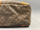 un gros plan d'un sac Louis Vuitton posé sur une surface blanche