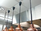 three copper colored lights hanging from the ceiling in a kitchen