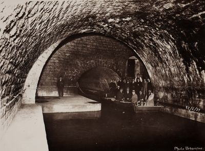 a black and white photo of a tunnel with people standing in it