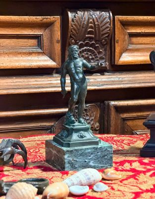 une statue représentant un homme tenant un poisson sur une table