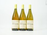 trois bouteilles de vin posées sur une table blanche
