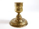 a gold cup sitting on top of a white table