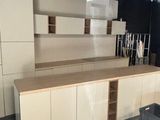 a room with a counter, cabinets, and a chair in it