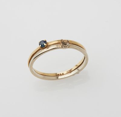 a yellow gold ring with a blue sapphire and a diamond