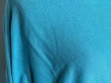 the back of a woman ' s blue shirt with a blue logo on it