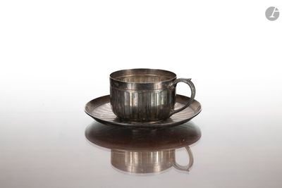 une tasse et une soucoupe en argent posées sur une table