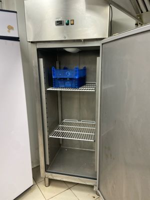 a refrigerator that is open and has a basket in it