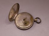 a silver pocket watch that has a key in it