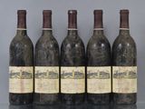 six bottles of wine are lined up on a table