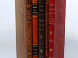 three books stacked on top of each other on a white surface