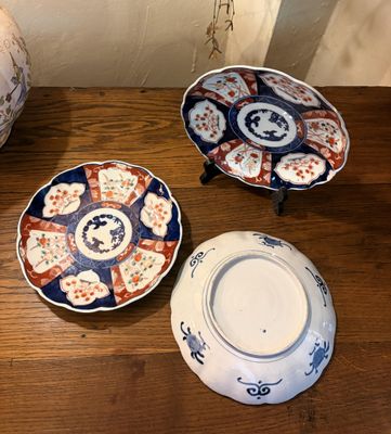 trois assiettes sur une table, avec un vase en arrière-plan