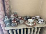une table sur laquelle sont disposées de nombreuses tasses à thé et soucoupes de différents types