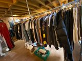 a lot of clothes hanging on a rail in a room