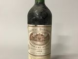 une vieille bouteille de vin posée sur une table blanche
