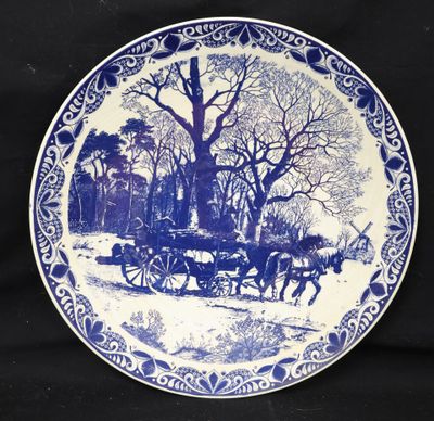 an image of a blue and white plate with a horse drawn carriage