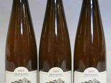 trois bouteilles de vin posées sur une table l'une à côté de l'autre