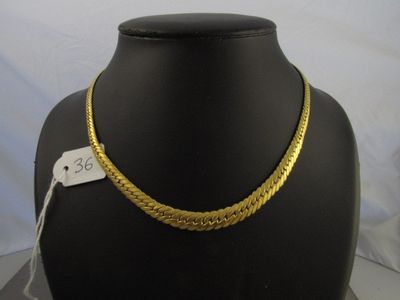 un gros plan d'un collier en or sur un mannequin