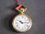 a gold pocket watch with roman numerals on it