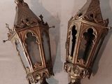 une paire de lanternes anciennes en laiton posées sur une nappe blanche