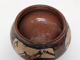 a small brown bowl with a bird design on it