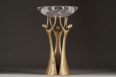 a close up of a gold vase with a glass bowl on top of it