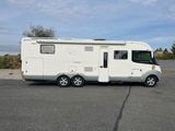 a small white rv parked in a parking lot