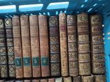 many old books in a blue basket on the shelf