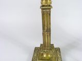 a gold colored lamp that is on a white table