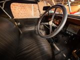 steering wheel and dashboard of an old car with a brick wall in the background