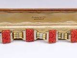 an image of three red and gold cuff bracelets in a case