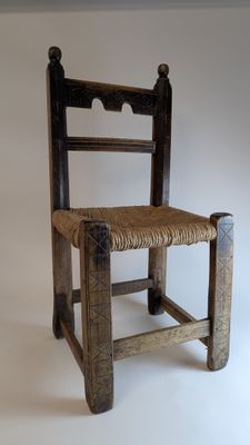 une chaise en bois avec une assise en osier sur fond blanc