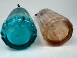 two different colored glass bottles sitting next to each other