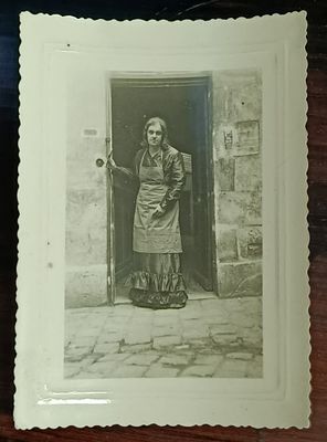 une photo en noir et blanc d'une femme debout devant une porte
