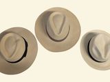 three hats sitting on top of each other on a white surface