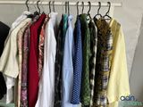 a lot of shirts hanging on a rack in a room