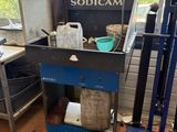 a blue cart with a metal container on it in a room