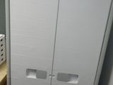 une armoire blanche et une chaise noire dans une pièce