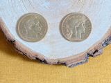 two coins sitting on top of a piece of wood