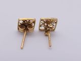 a pair of gold earrings on a white background