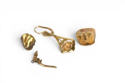 trois bijoux en or posés sur une surface blanche