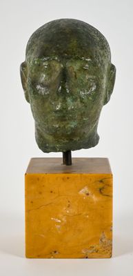 an image of a sculpture of a man ' s head on a wooden stand