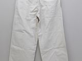 a pair of white pants hanging on a hanger on a wall