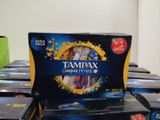 a box of tampax on top of a pile of other boxes