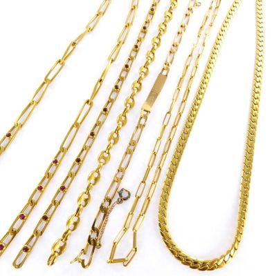 a close up of a bunch of gold chains on a white surface