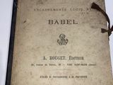 an old book on a table with a glass of wine next to it