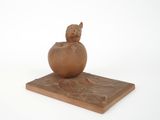 a small figurine of a cat sitting on top of an egg