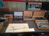 de nombreux outils posés sur une table, avec un ordinateur portable à l'arrière-plan